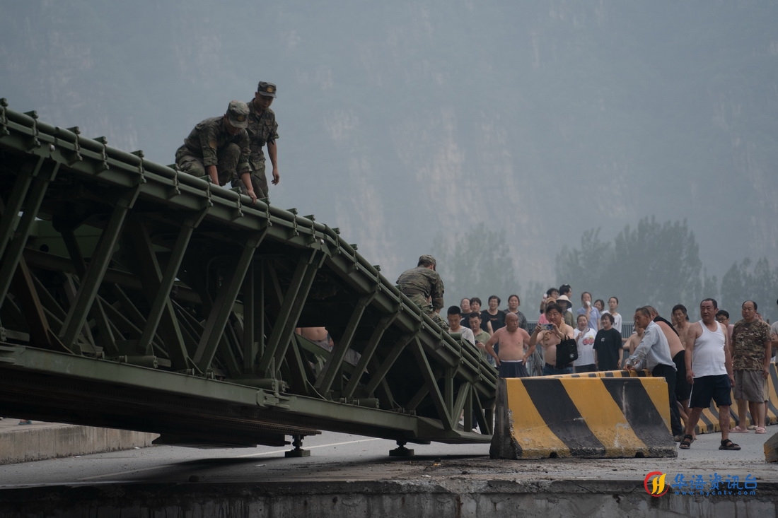 8月3日，中部战区陆军第82集团军某旅在北京市房山区涞宝路四渡桥断桥处架设桥梁，官兵们将导梁架设到对岸。新华社发（张康 摄）