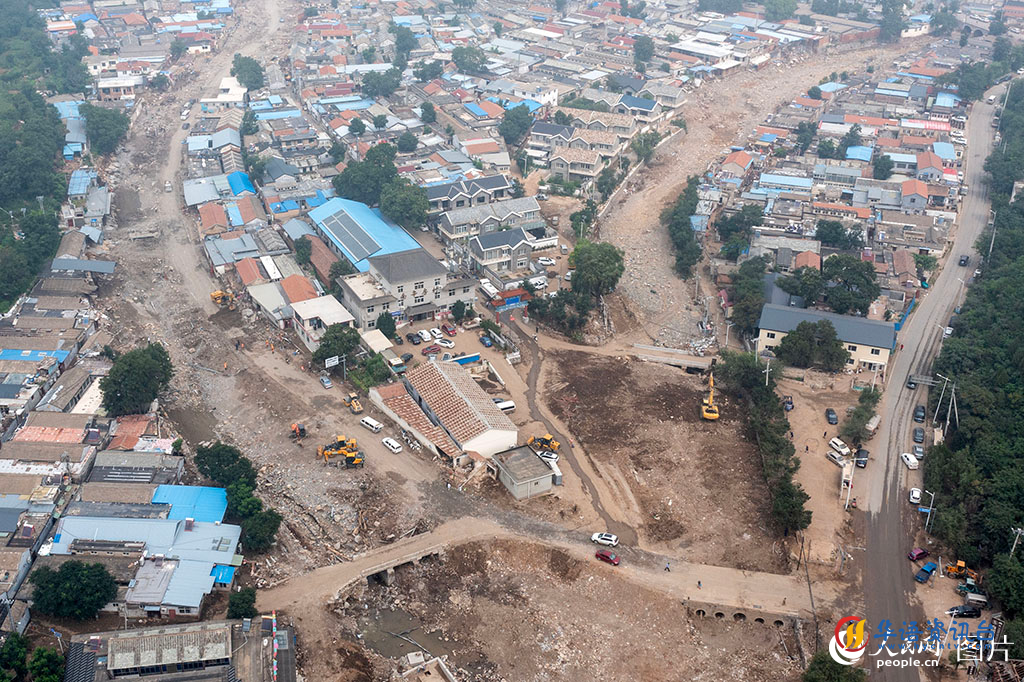 8月10日，在北京门头沟区潭柘寺镇，大型机械正在清理平整路面。人民网记者 翁奇羽摄