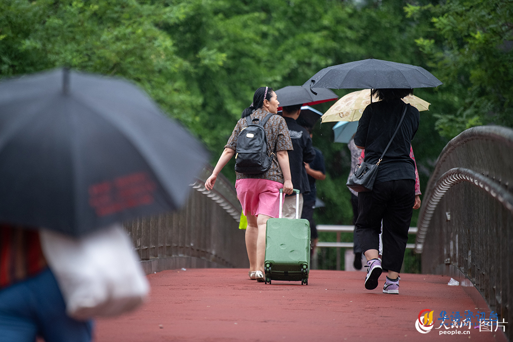 7月31日，北京市民冒雨出行。