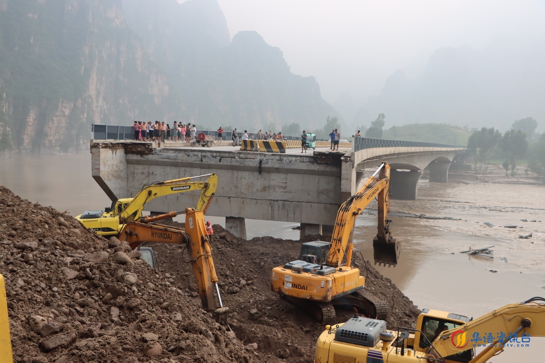 北京市房山区涞宝路四渡桥路基被洪水冲毁，桥面坍塌，中部战区陆军第82集团军某旅官兵抵达时，地方施工队伍在回填路基（8月3日摄）。新华社发（张康 摄）