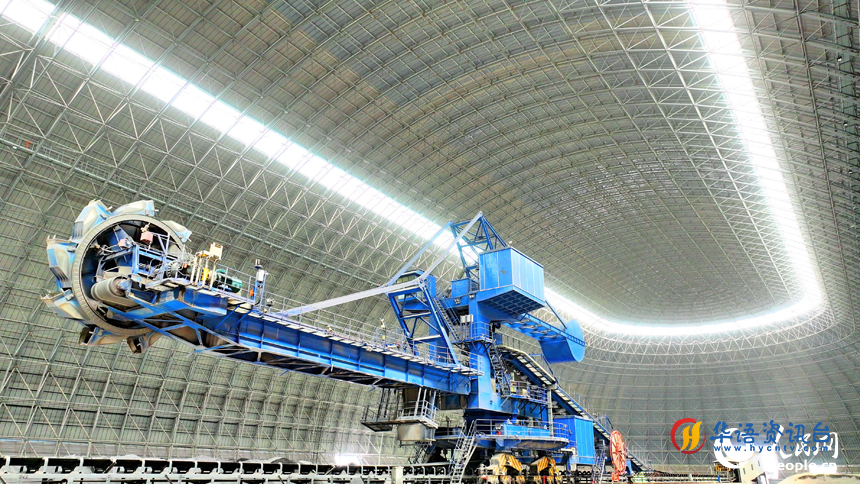 九江市柴桑区的九江港赤湖作业区公用码头全封闭智慧“胶囊”仓库内,大型机械设备在进行取料作业。人民网 朱海鹏摄