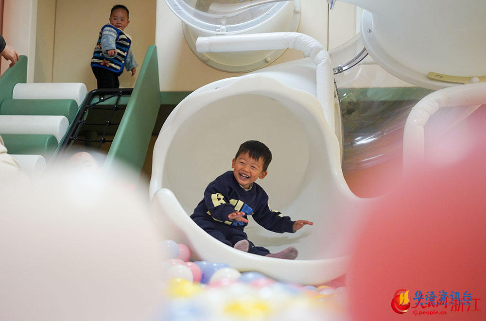 在宁波市镇海区招宝山街道邻里中心，小朋友在滑滑梯。人民网 章勇涛摄