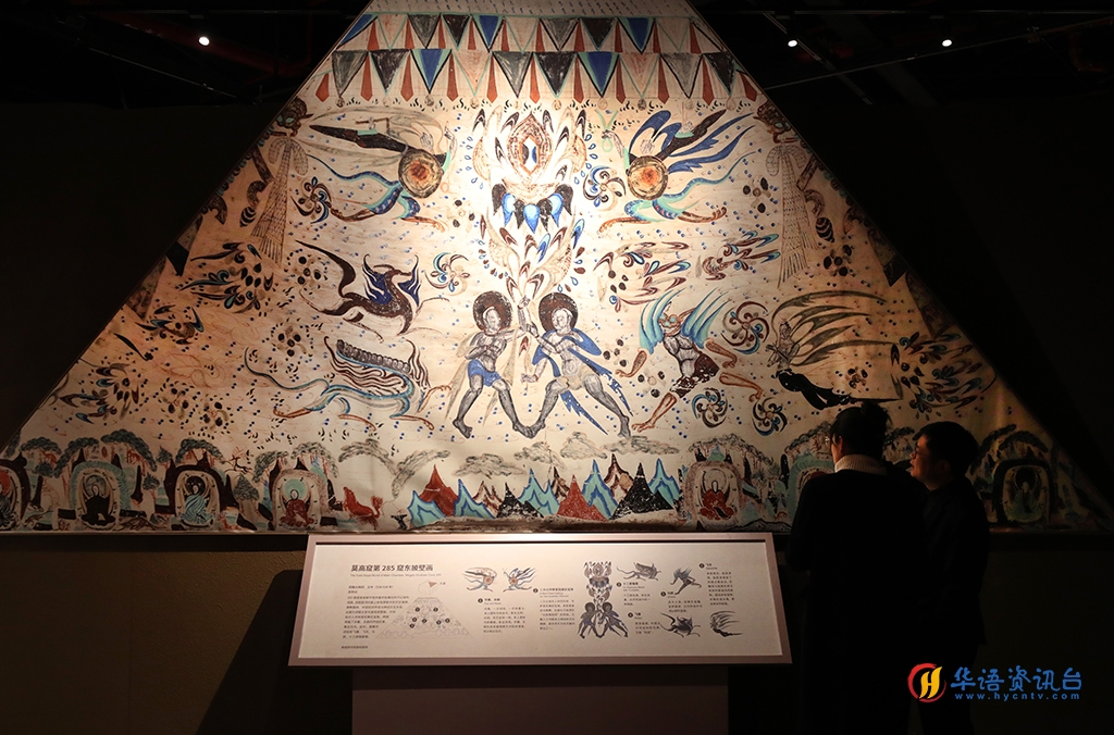 12月21日，参观者在莫高窟第285窟东披壁画（复制品）展品前交流讨论。新华社记者 方喆 摄