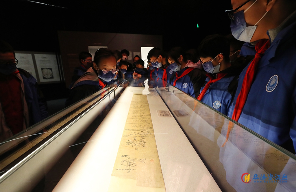 12月21日，前来参观的中学生在莫高窟藏经洞出土的唐代全天星图（复制品）展柜前驻足观看。新华社记者 方喆 摄