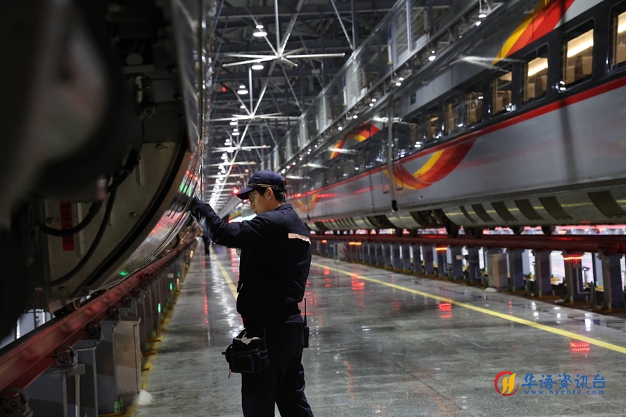 动车组机械师正在对车组两侧进行检查。 谭文卿摄