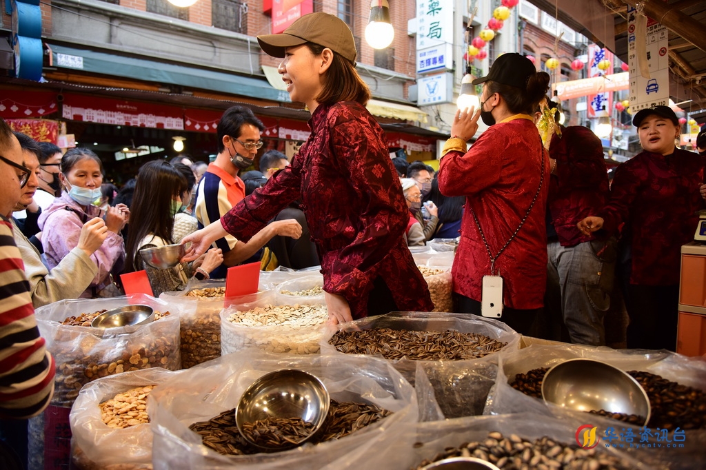 2月3日，在台北市迪化街，一处店铺的店员在向采买年货的顾客叫卖。新华社记者 陈键兴 摄