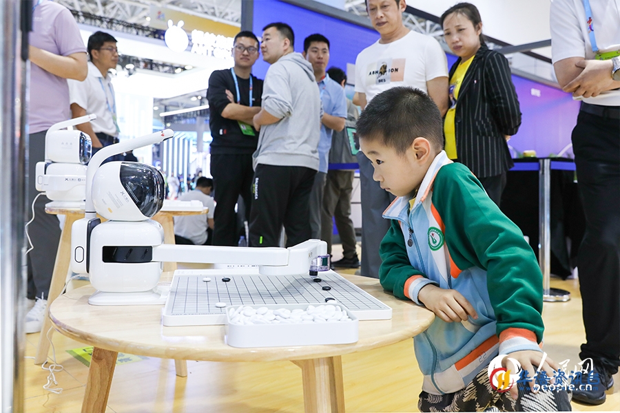 小朋友专注的与机器人对弈。人民网 陈永整摄