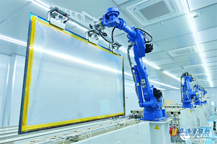 一排排智能机器人正转动机械臂加工透明导电膜。人民网 朱海鹏摄