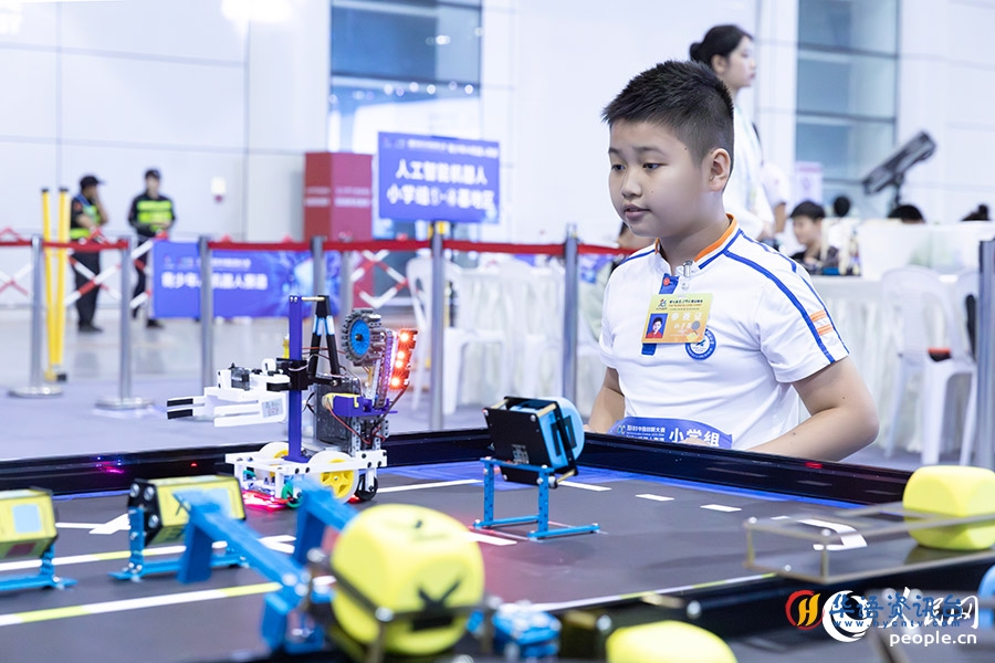 03参赛学生屏息凝神盯着自己的机器人。人民网记者-焦艳摄