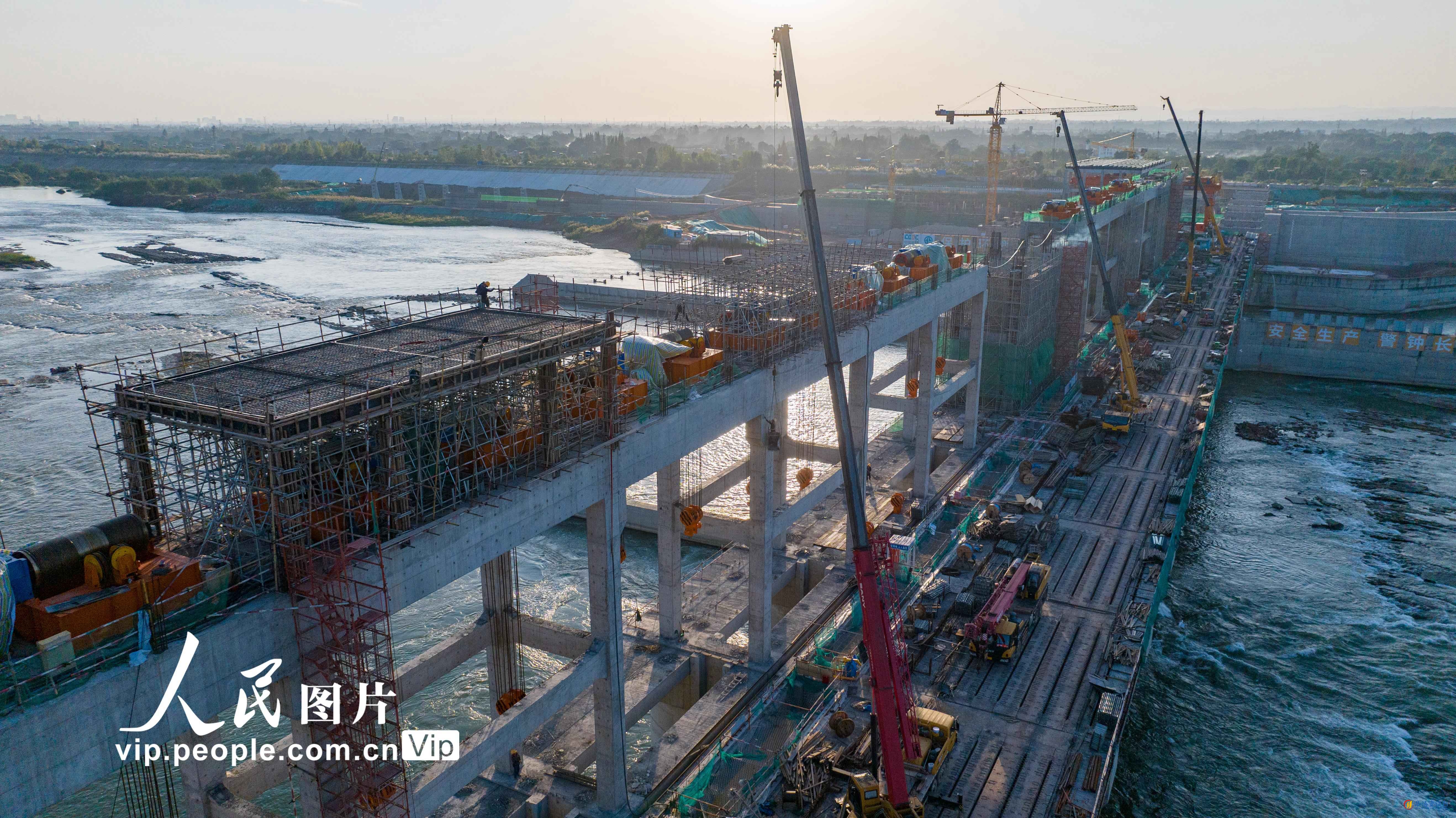 2024年10月22日，工人正在进行坝顶板梁结构施工及发电机组和启闭设备安装工作。