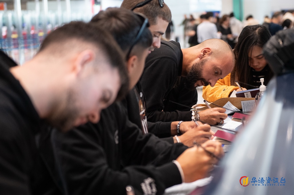 12月4日，外国游客在北京首都机场三号航站楼边检入境现场填写入境卡。新华社记者 陈钟昊 摄