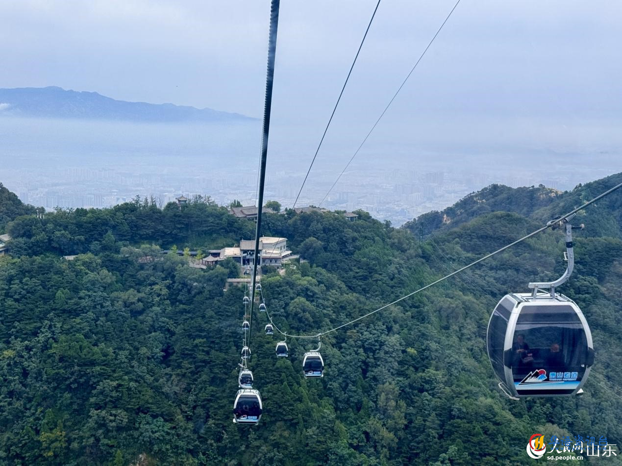 游客乘着缆车穿梭,云海峰峦尽收眼底。人民网 郑昕桥摄